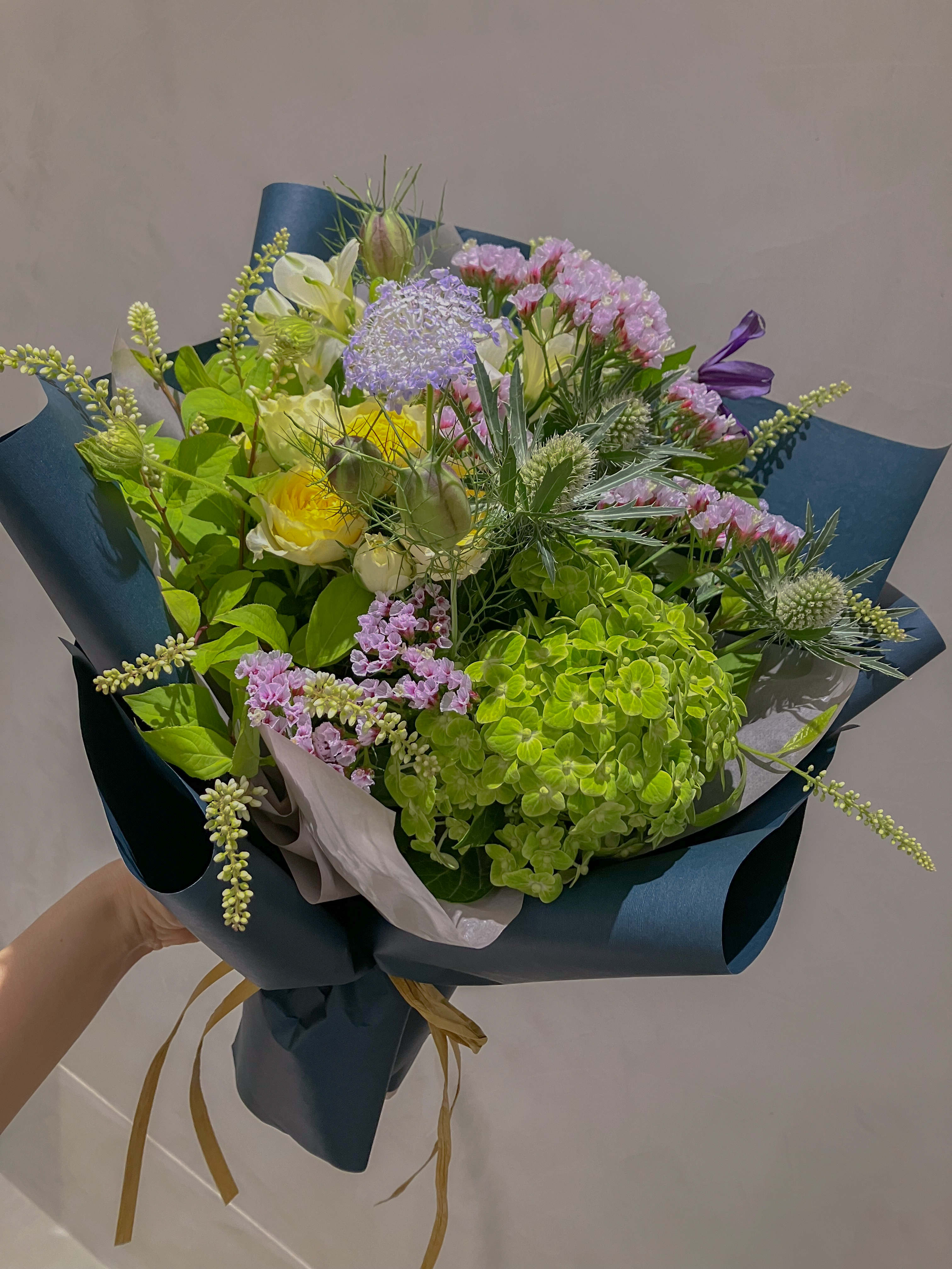 Hand holding white peonies bouquet